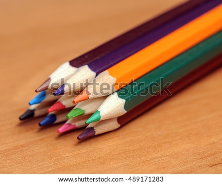 Colored pencils on a wooden board. Macro photo of colored pencils