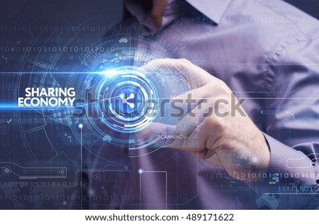 Business, Technology, Internet and network concept. Young businessman working on a virtual screen of the future and sees the inscription: sharing economy