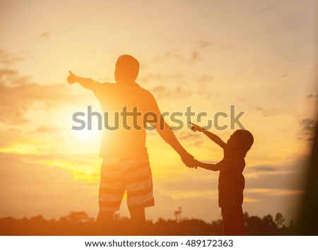 Happy dad throws the baby at sunset 