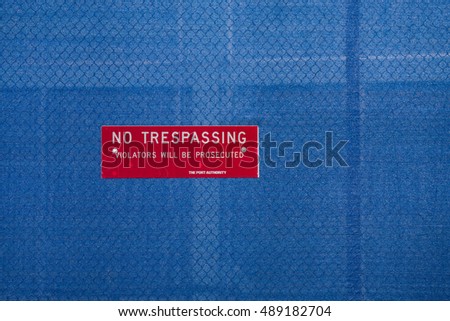 Red warning sign - blue background "No Trespassing"