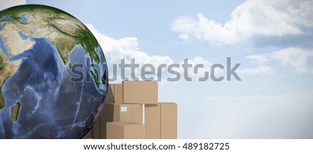 Earth surrounded by cardboard boxes against blue sky