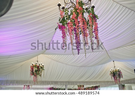 Colorful flowers on the luster in the wedding tent