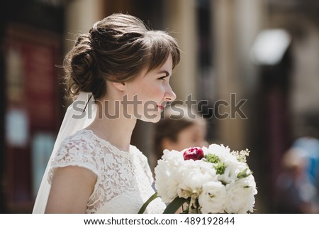 The charming bride stands with bouquet