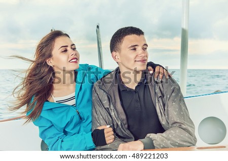 Happy couple woman and man, travel sailing on open sea 