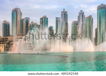The Dubai Fountain, the world largest choreographed fountain on Burj Khalifa Lake, performs at sunset, to the beat of the selected music. On background, skyscrapers of Old Town Island near Dubai Mall. Royalty-Free Stock Photo #489242548