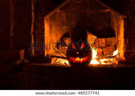 Halloween creepy pumpkin fireplace with fire, isolated in the orange dark