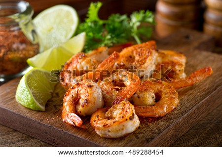 Delicious sauteed shrimp with cajun seasoning and lime on a maple plank. Royalty-Free Stock Photo #489288454