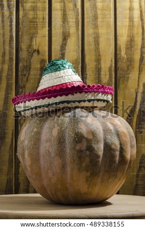 Halloween pumpkin with mexican hat on wooden background