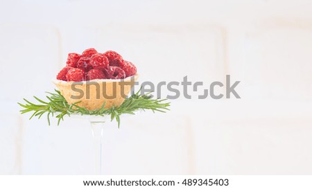 Raspberry tart with rosemary decoration on white background. High key image. Holiday season dessert. Holidays background. Warm color. Horizontal, wide screen format