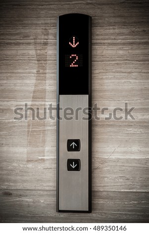 Elevator Button up and down direction with down red light on granite background