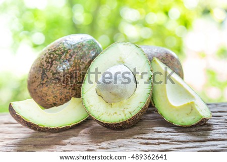 Avocado on a wooden floor and has a background of nature
