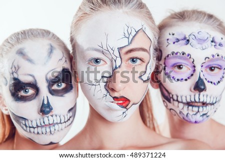 Three girls with Halloween face art on white background