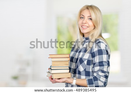 Beautiful young woman holding books