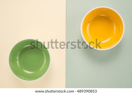 Two empty bowl on a color cardboard