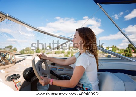 Woman behind the wheel yacht, enjoying nature and river landscape, active sailor girl, female driving luxury water transport, summertime concept