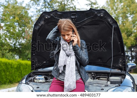Picture of a helpless young woman with her car broken