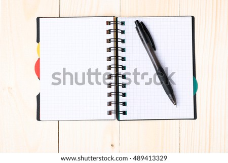 notepad with pen isolated on wood background