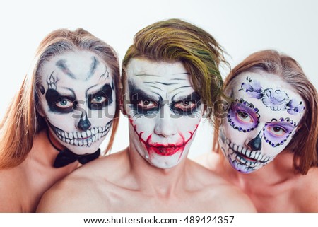 Two girls and a guy with Halloween face art on white background