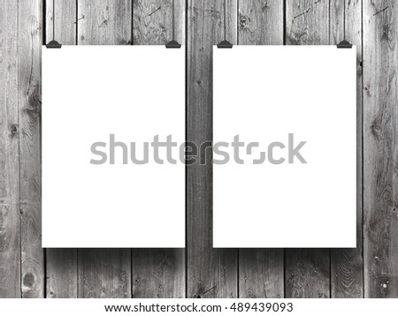 Close-up of two blank frames hanged by clips against gray weathered wooden boards background