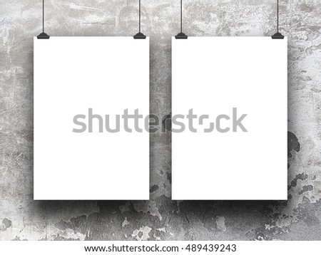 Close-up of two blank frames hanged by clips against gray scratched concrete wall background