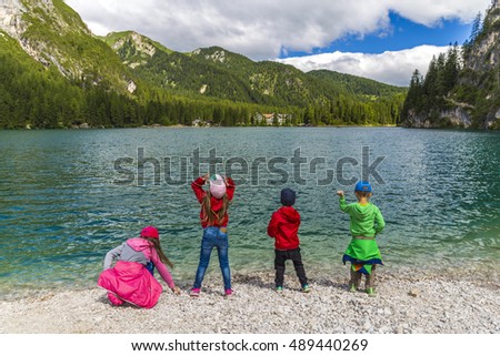 A group of kids watching a lake in front of mountains, Lago di Braies, Dolomites, Italy