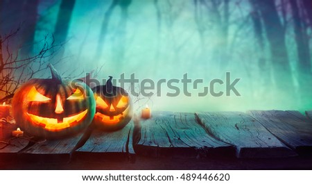 Halloween background. Spooky forest with dead trees and pumpkins.Halloween design with pumpkins Royalty-Free Stock Photo #489446620