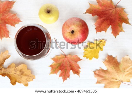 still life with a glass of drink different leaves and ripe fruit top view / tasting autumn gifts