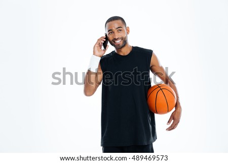 Happy african young basketball player talking on mobile phone isolated on a white background