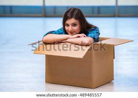 Young woman with box in moving house concept