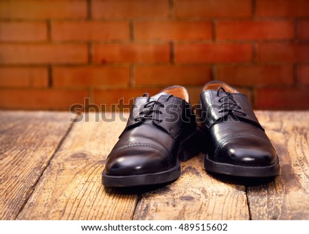 black men's shoes on wooden background