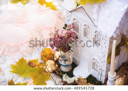 Small house and bouquet of flowers in autumn park