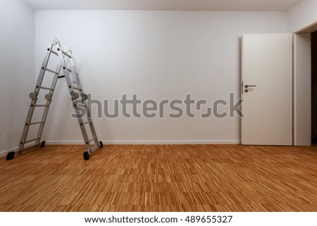 Empty, clean white room with aluminum ladder