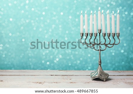 Menorah with candles for Hanukkah celebration over bokeh background