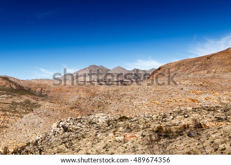 Beautiful clouds and mountains overlooking the barren landscape.