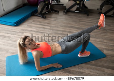 Woman make pilates exercise lying on floor in gym