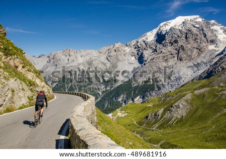 Cyclist ride downhil under the big alpen mountains
