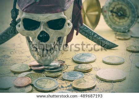 Skull wears a red bandanna and a pile of coins on an ancient map with a compass behind. An idea of guarding / keeping / protecting valuable treasures by the honest minion for his master eternally.