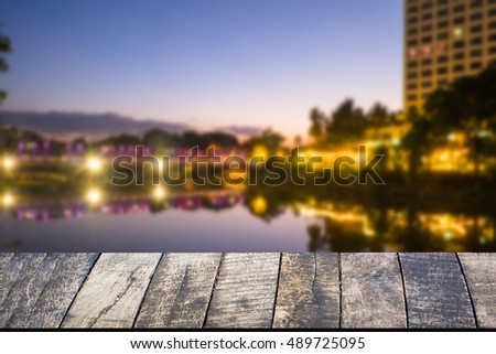 Empty of wood desk form and bokeh light of night city scape background for product presentation display montage.