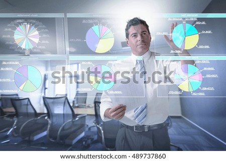 Businessman looking at pie charts on interactive screen