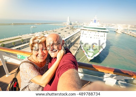 Senior happy couple taking selfie on ship on harbor background - Mediterranean cruise travel tour - Active elderly concept with retired people around the world - Bright sunny afternoon color tones Royalty-Free Stock Photo #489788734