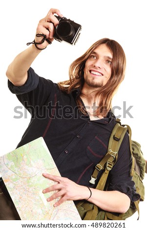 Man tourist backpacker on trip taking photo picture with camera. Young guy hiker backpacking holding map. Summer vacation travel. Isolated on white background.