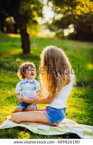 beautiful young mother with her son sitting in a park