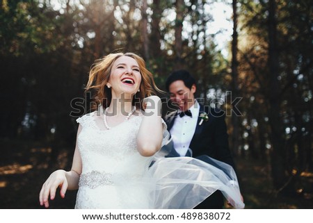 very happy bride and groom standing together outdoors