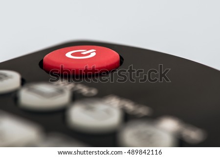 Closeup image of a red power button on a remote control for a TV or another entertainment device.