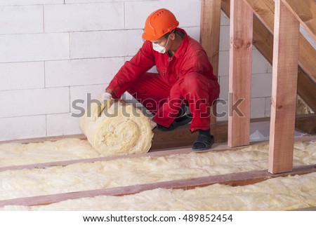 working insulates the attic with mineral wool Royalty-Free Stock Photo #489852454