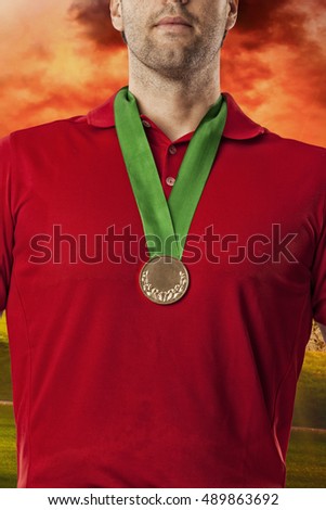Golf Player in a red shirt celebrating with a golden medal, on a golf course.