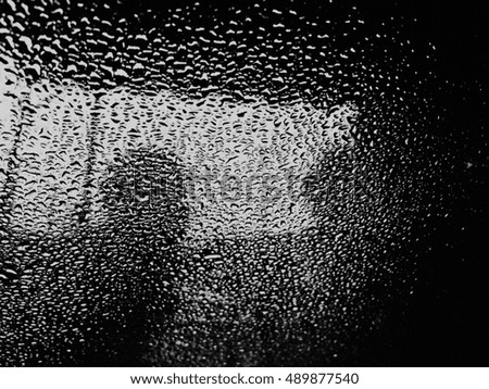 Water drop on glass and human view dark tone
