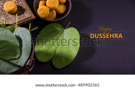 Happy Dussehra / Vijayadashami / Ayudh Puja greeting card using apta/Bauhinia racemosa/Bidi leaf and indian sweet pedha or pera Royalty-Free Stock Photo #489902365