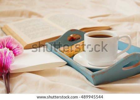 Romantic breakfast in the bed: cookies, hot coffee, flowers and blank note for adding text