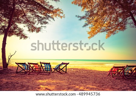 Sea sand sky and vintage summer day. Foot print on a summer sandy ocean beach. Lounge chair in the tropical beach. Close up sand with blurred sea sky background, summer day, copy space for product. 